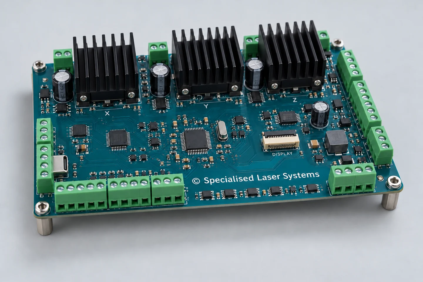 Illustrative teal controller PCB with an integrated processor, motor-drive heatsinks, connection terminals and Specialised Laser Systems copyright on the silkscreen