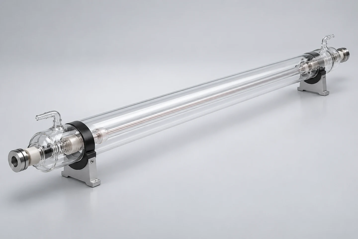 Illustrative clear glass CO₂ laser tube showing its internal bore, water connections and two mounting supports